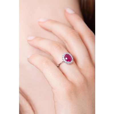 Bague en or blanc 18k avec rubis ovale et entourage de diamants