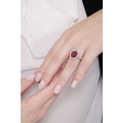 Bague en or blanc 18k avec rubis ovale et halo de diamants