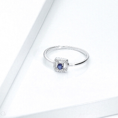 Bague en or blanc 18 carats avec saphir bleu central et contour en diamants